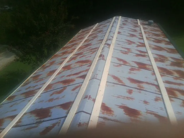 Rusted metal roof panels with new wood purlins before replacement — Storm Damage Roof Repair in Avella by Roofing Brothers