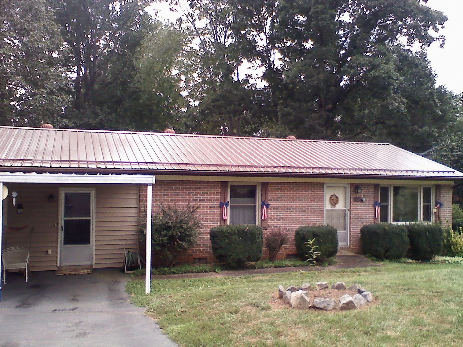 Bronze metal roof and carport on a brick ranch home — Roof Repair work by our crew in Avella